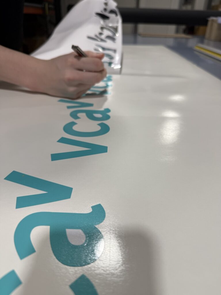 Belettering in folie voor VCA wordt gepeld